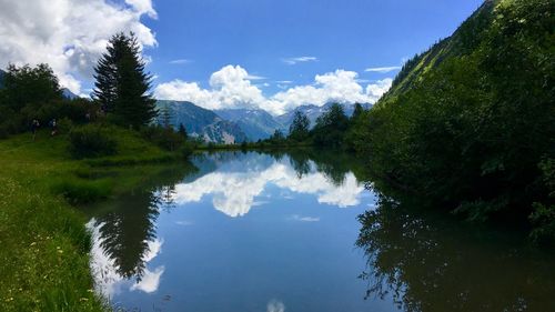 Scenic view of lake by trees against sky