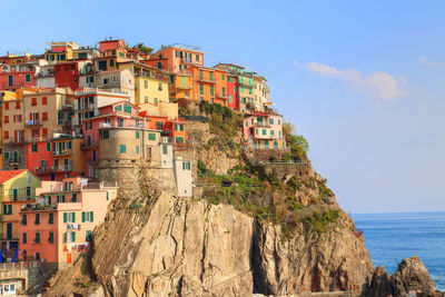 Buildings by sea against sky