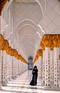 Full length of woman walking in corridor at mosque