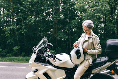 Side view of man riding motorcycle on road