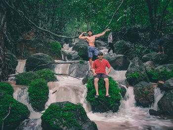 Full length of man climbing rock in forest