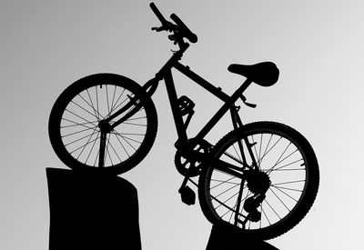 Low angle view of silhouette bicycle against clear sky
