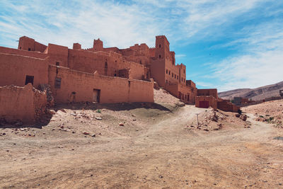 Old buildings on desert against sky