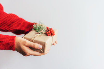 Midsection of woman holding gift box against white background