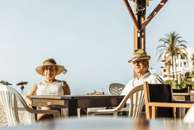 Senior couple sitting at a bar terrace at the beach, el roc de sant gaieta, spain