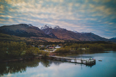 Scenic view of lake by mountains against sky