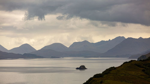 Scenic view of sea and mountains against sky