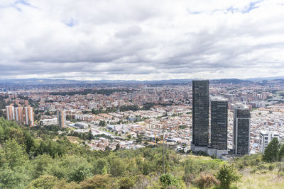 Aerial view of buildings in city against sky