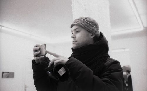 Portrait of young man looking through window