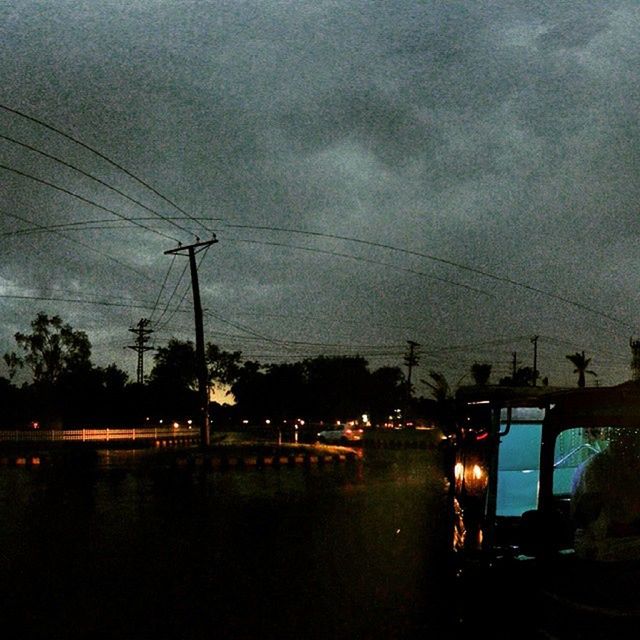 power line, electricity pylon, electricity, transportation, sky, power supply, cable, connection, street light, tree, dusk, fuel and power generation, cloud - sky, car, mode of transport, silhouette, street, road, weather, illuminated