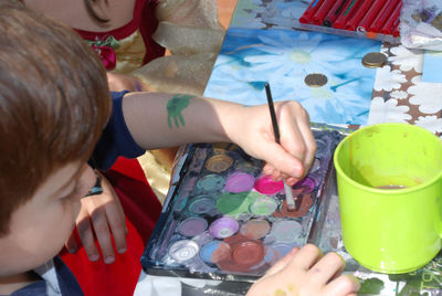 High angle view of boy painting on paper