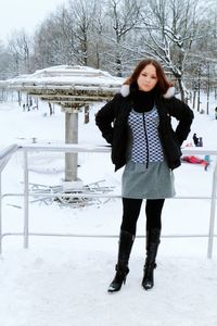 Full length of young woman standing in snow