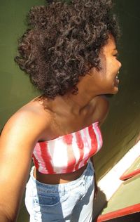 High angle view of woman looking over shoulder while standing against wall