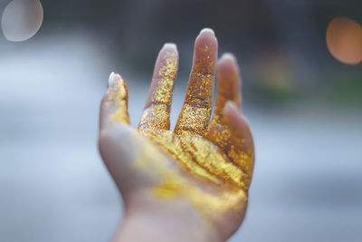 Cropped hand of woman with golden glitter