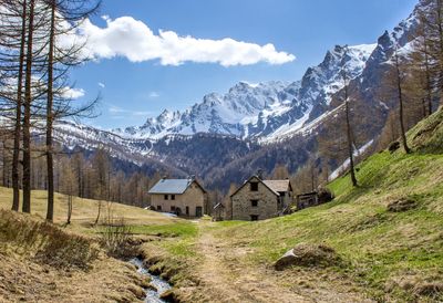 Houses on hill against mountains and sky during sunny day