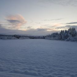 Scenic view of frozen landscape against sky during winter