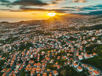 High angle view of illuminated cityscape against sky during sunset