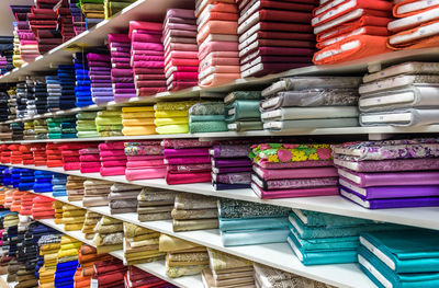 Full frame shot of multi colored rolled up fabrics for sale on shelves