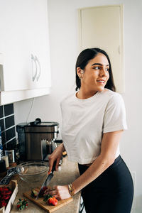 Smiling young man standing in kitchen at home