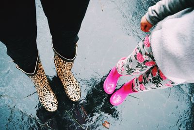 Low section of people standing on wet road