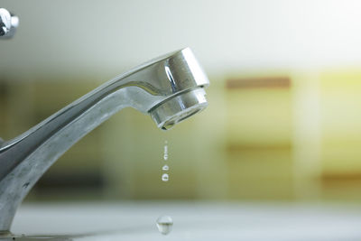 Close-up of water falling from faucet in bathroom