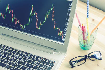 High angle view of forex chart on laptop screen at desk