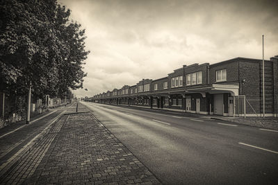 Empty road along buildings