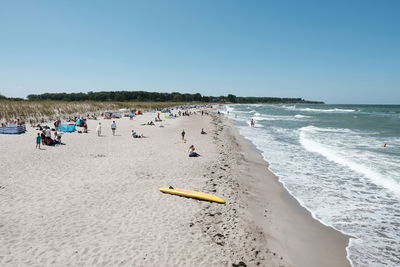 People on beach against clear sky