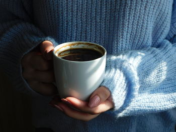 Close-up of hand holding coffee cup