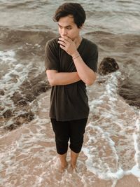 Young man standing on beach
