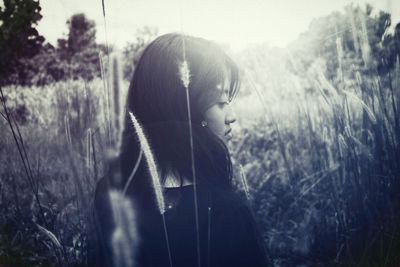 Rear view of young woman standing amidst plants