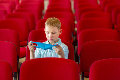 Full length of boy sitting on chair