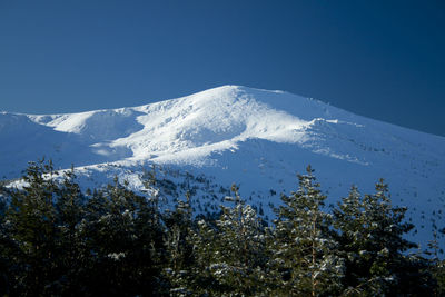 Scenic view of snowcapped mountains against clear blue sky