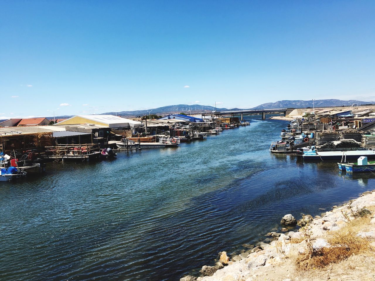 architecture, building exterior, built structure, clear sky, water, blue, city, cityscape, residential district, residential structure, residential building, town, outdoors, day, sky, townscape, travel destinations, no people, city life, nature, scenics, tourism, sunny