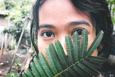 Close-up portrait of young woman covering face