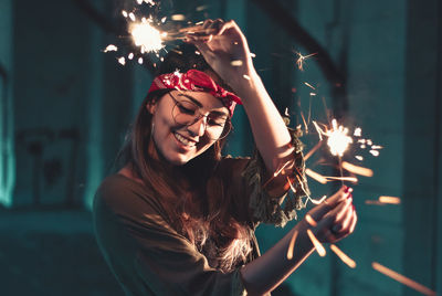 Young woman with fire crackers at night