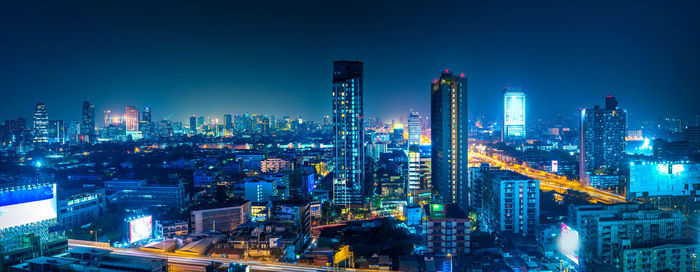 Illuminated cityscape against sky at night