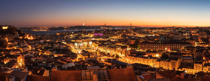 High angle view of illuminated cityscape against sky at dusk