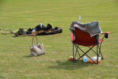 High angle view of tent with purse and folding chair on field at campsite