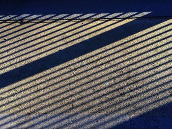 High angle view of shadow on footpath during sunny day