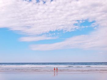 Scenic view of beach against cloudy sky