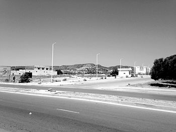 Vehicles on road against clear sky