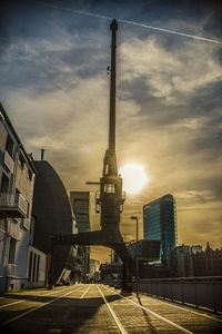 Street amidst buildings against sky during sunset