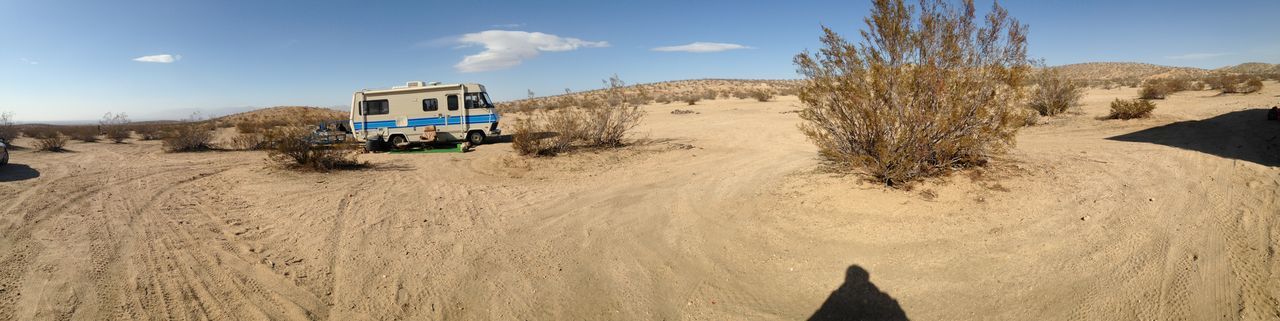 sky, sand, building exterior, architecture, built structure, beach, sunlight, cloud, shadow, tranquility, nature, house, cloud - sky, day, blue, tranquil scene, landscape, outdoors, no people, desert