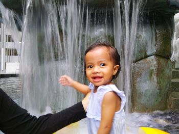 Portrait of smiling baby girl against fountain