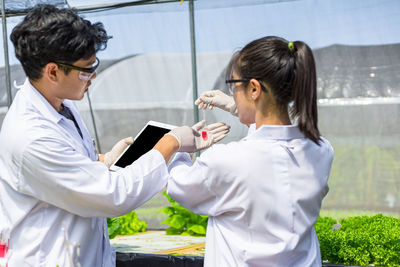 Side view of man and woman holding mobile phone