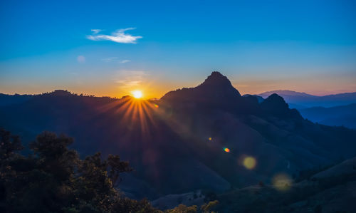 Scenic view of silhouette mountains against sky during sunset