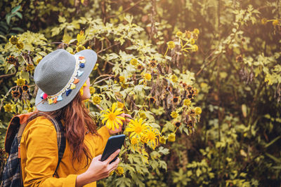 Woman looking at flowering plant