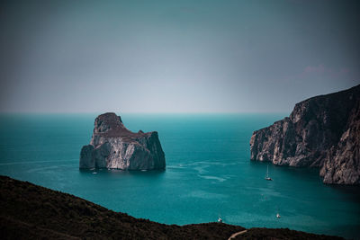 Scenic view of rocks in sea against sky