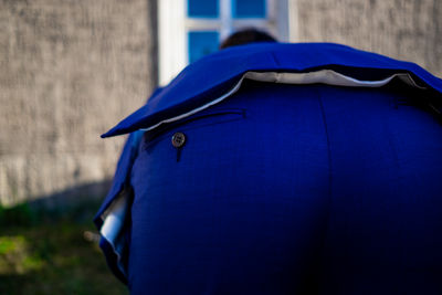 Rear view of man against blue wall
